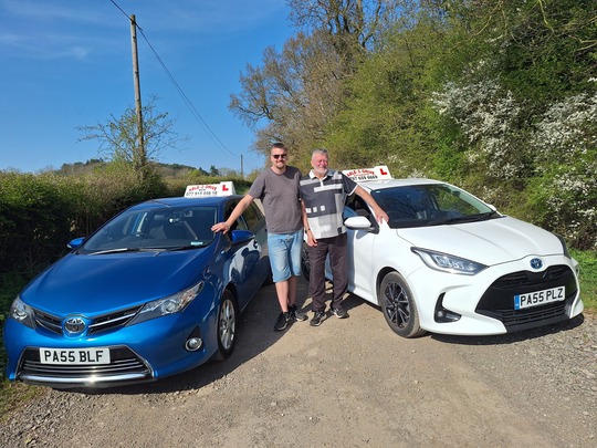 A photo on instructors Jon and Ben stood next to their cars in a field